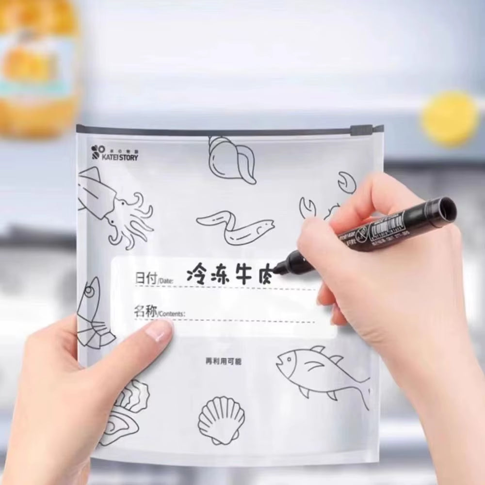 Person labeling a transparent reusable food storage bag with sea creature illustrations, writing “frozen beef” in Chinese, designed for organized meal prep and freezer storage.