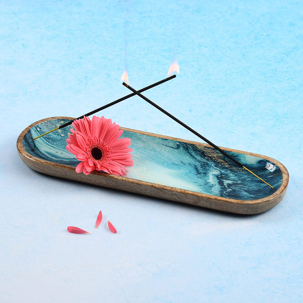 Blue marble incense holder with wood frame—two burning sticks, pink gerbera flower, and rising smoke for calming aromatherapy display