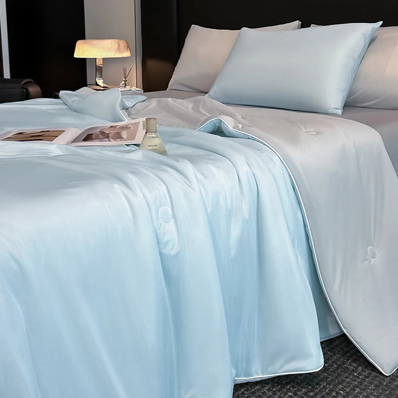 Light blue cooling blanket summer quilt on bed with pillows for hot sleepers