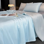 Light blue cooling blanket summer quilt on bed with pillows for hot sleepers