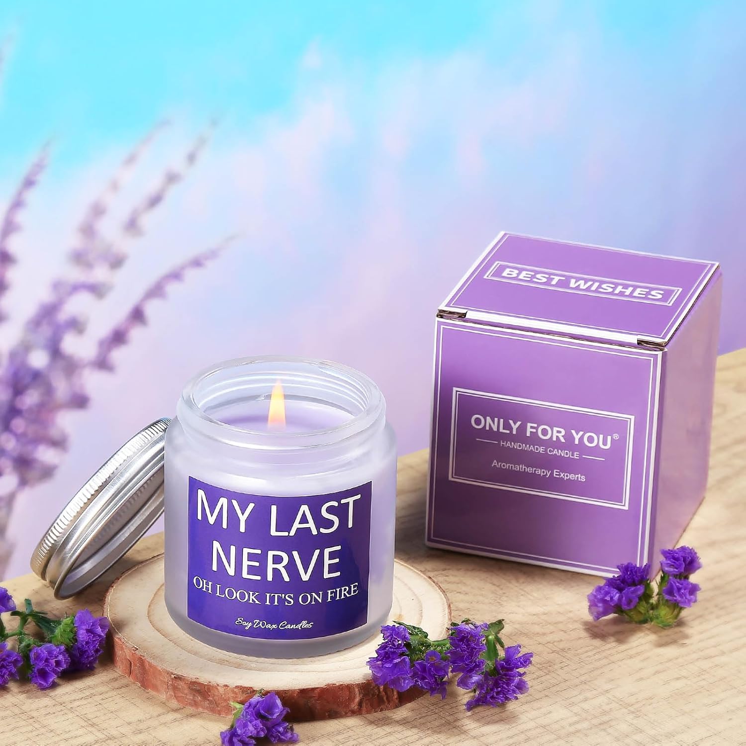 Lit lavender aromatherapy candle with humorous label “MY LAST NERVE OH LOOK IT’S ON FIRE”—displayed beside matching purple gift box and flowers on wooden coaster, perfect for stress relief and gifting