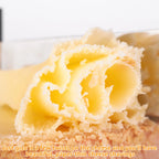 Close-up of delicate paper-thin cheese shavings made with stainless steel cheese curler cutter