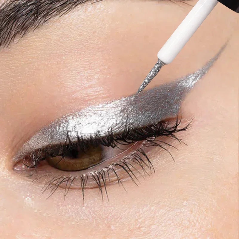 Close-up of silver metallic eyeliner being applied in a dramatic winged style with precision brush