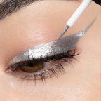 Close-up of silver metallic eyeliner being applied in a dramatic winged style with precision brush