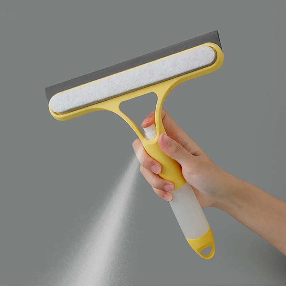Hand using yellow window squeegee with built-in mist spray—cleans glass surface with absorbent pad and rubber blade for streak-free finish