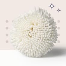 White microfiber bath scrubber with soft textured surface—gentle exfoliating tool for body cleansing and skincare routine